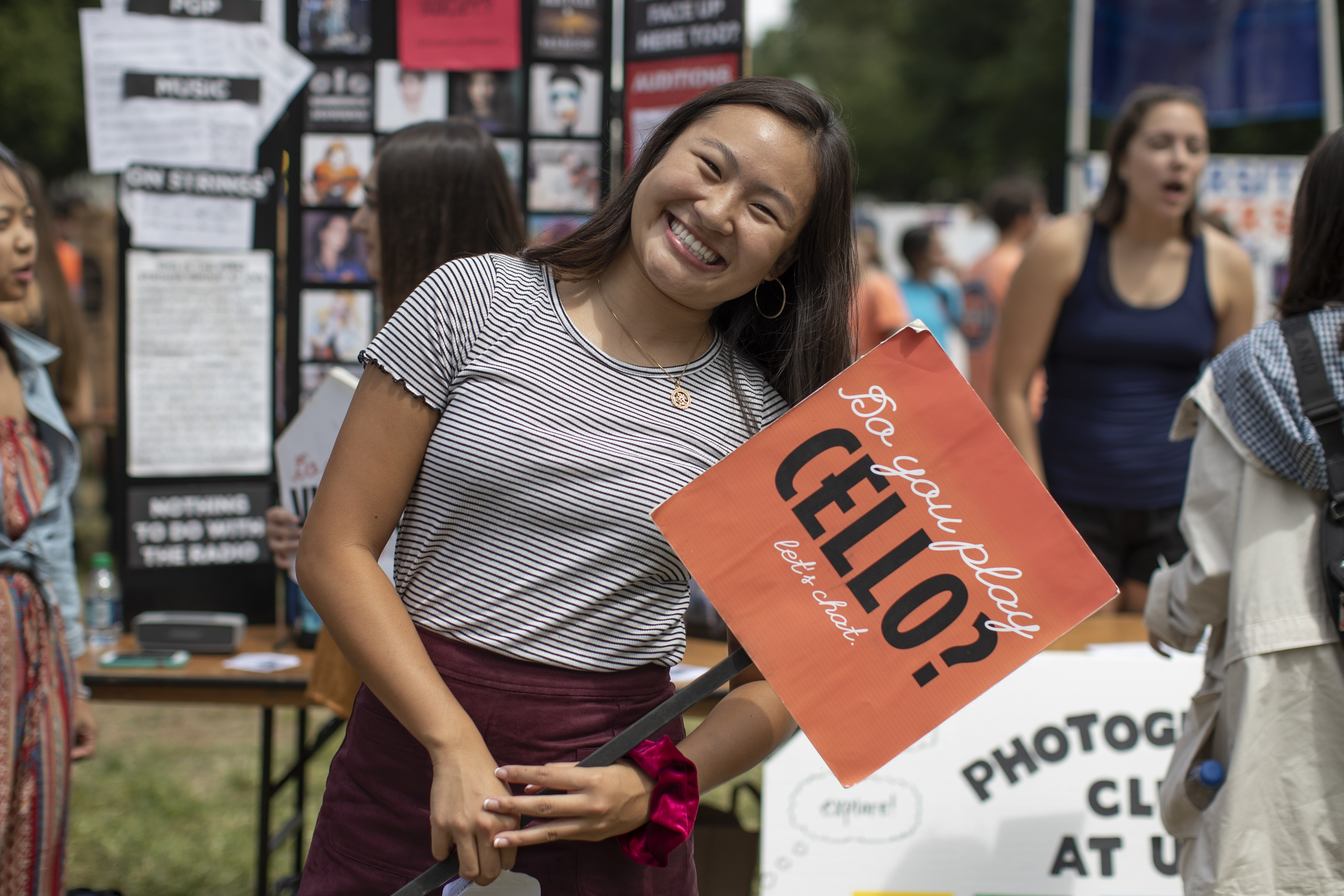 a student holds a sign to recruit club members during the fall activities fair